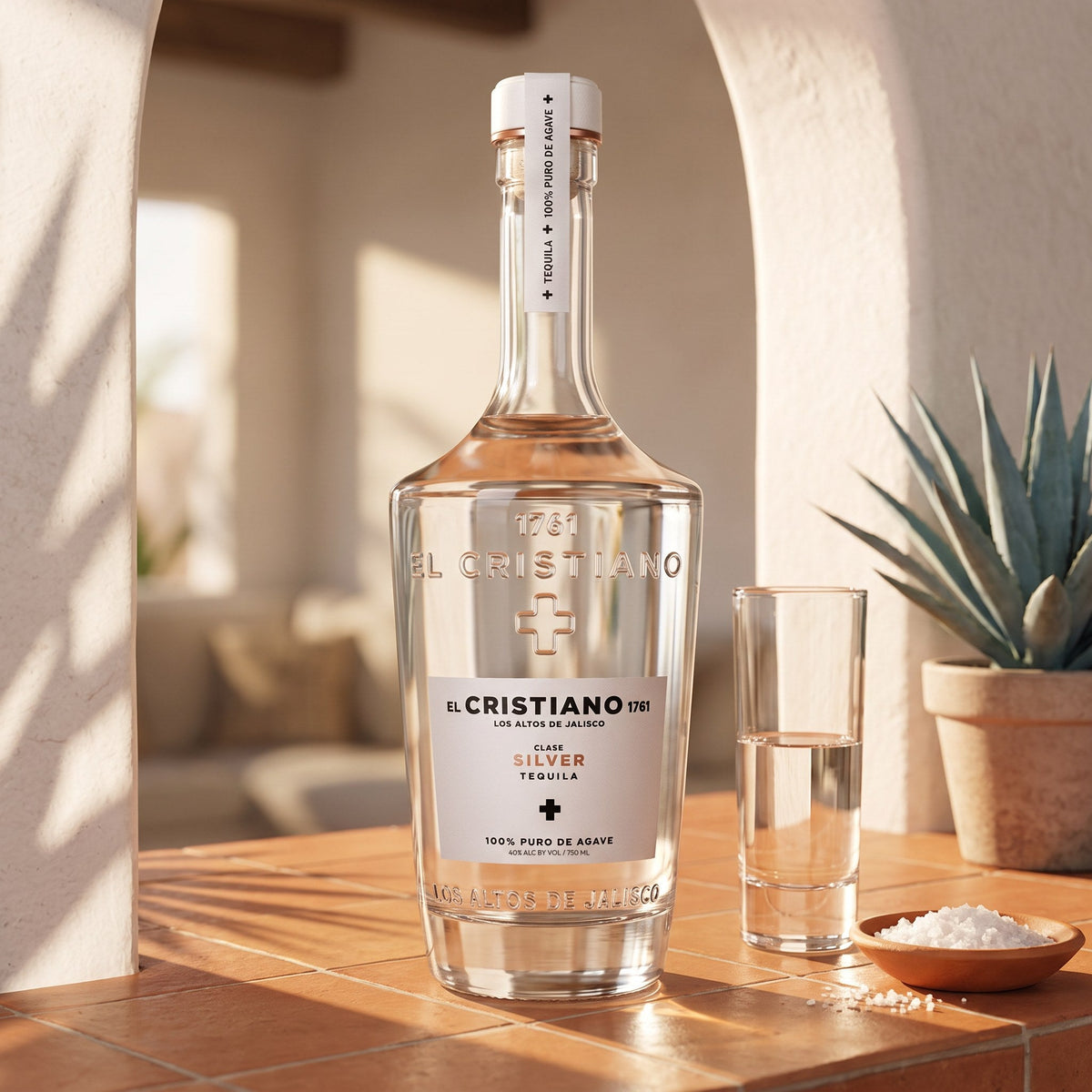 El Cristiano Silver Tequila, 80 proof, on a terracotta-tiled home bar in a sunlit adobe niche, with a caballito of blanco, sea salt and a potted blue agave