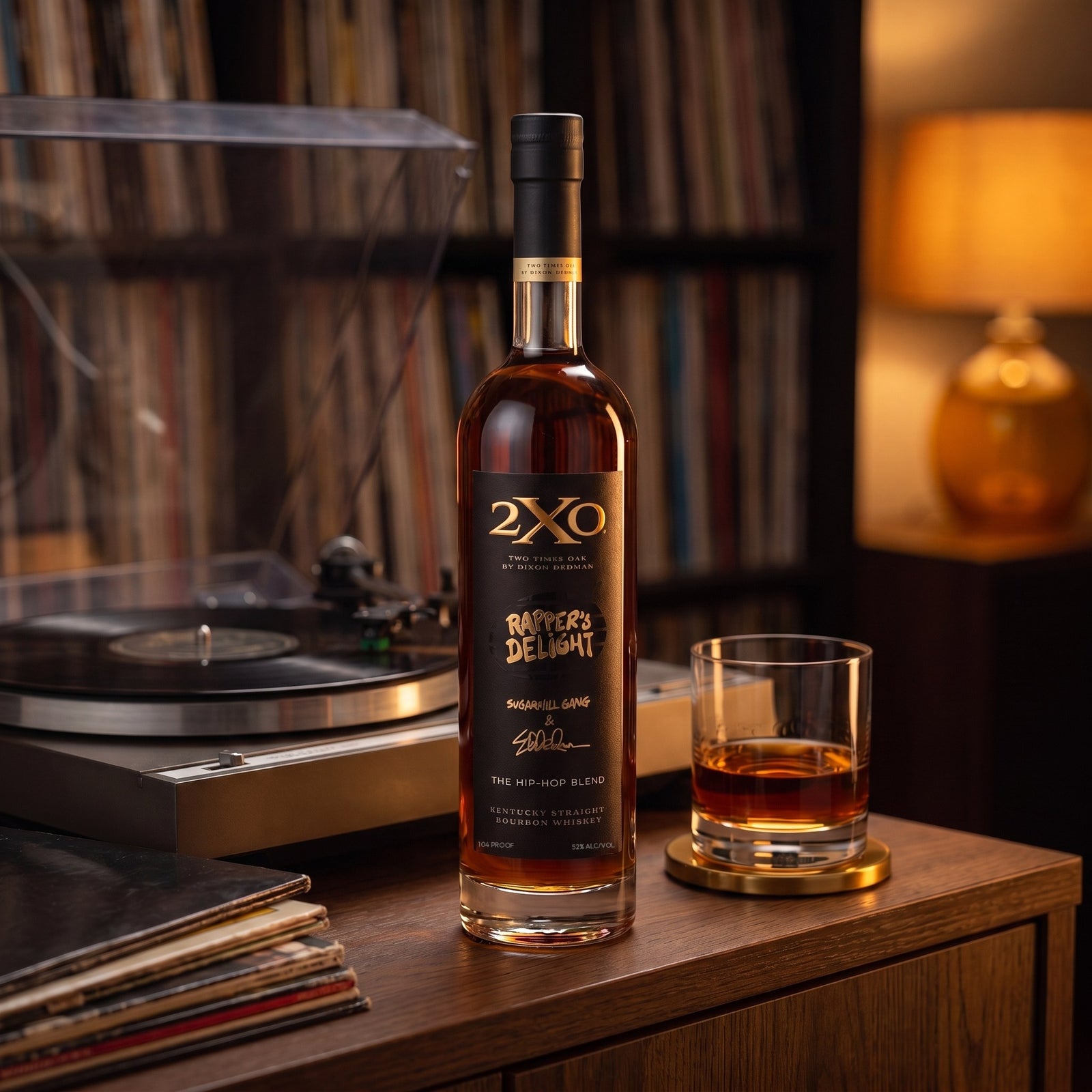 2XO Rapper's Delight Hip-Hop Blend bourbon on a home bar beside a turntable and a wall of records