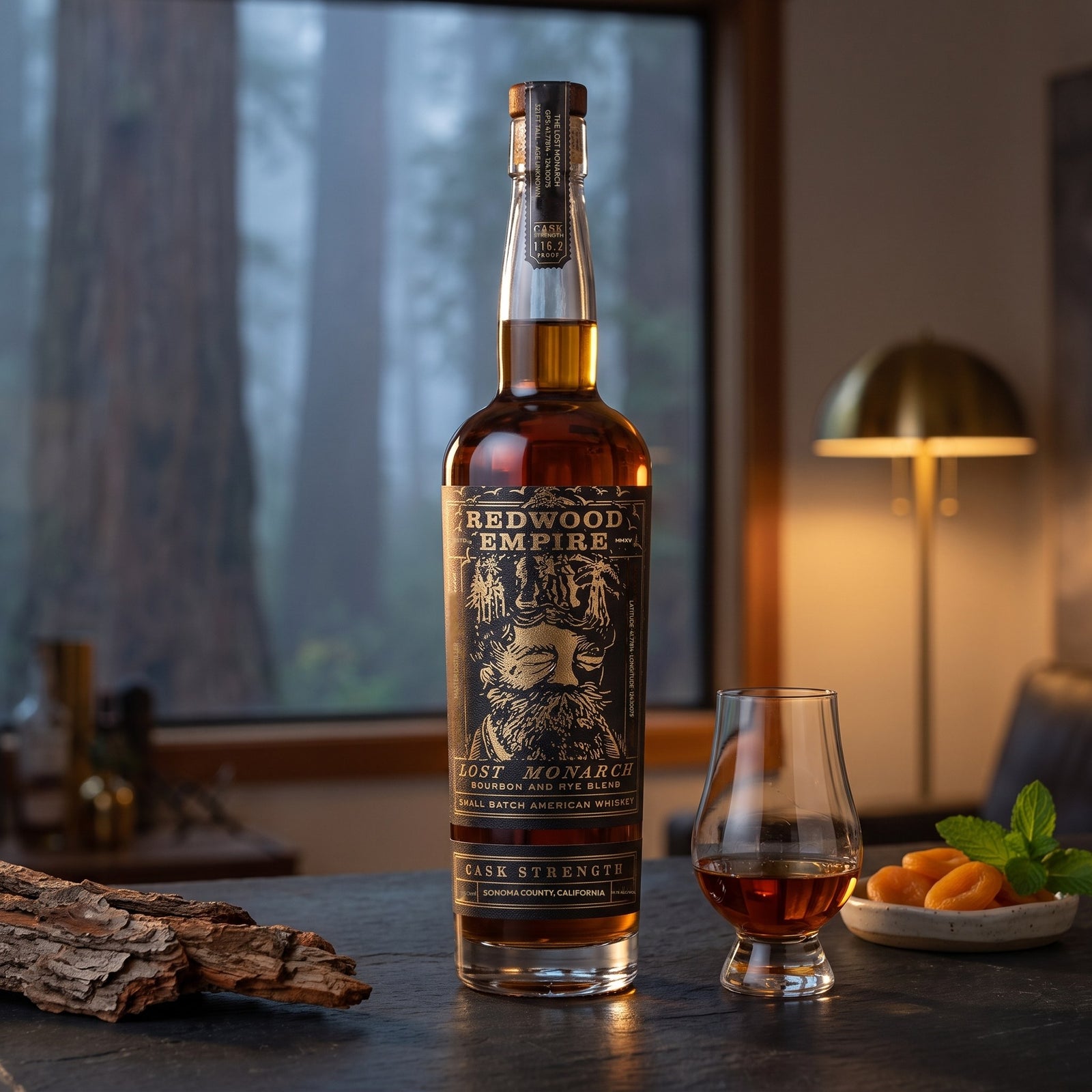 Redwood Empire Lost Monarch Cask Strength 116.2 proof on a slate bar beside a Glencairn pour, dried apricots and mint, fog in the redwoods outside