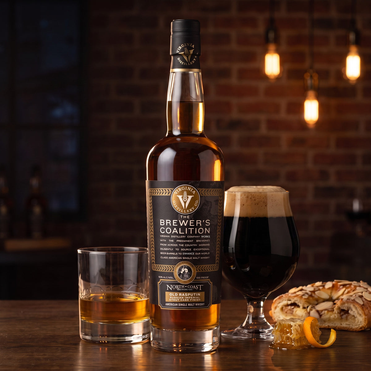 Virginia Distillery Co. Brewer's Coalition Old Rasputin Stout Cask Finish single malt on an oak pub table beside a neat pour, a glass of imperial stout and almond kringle