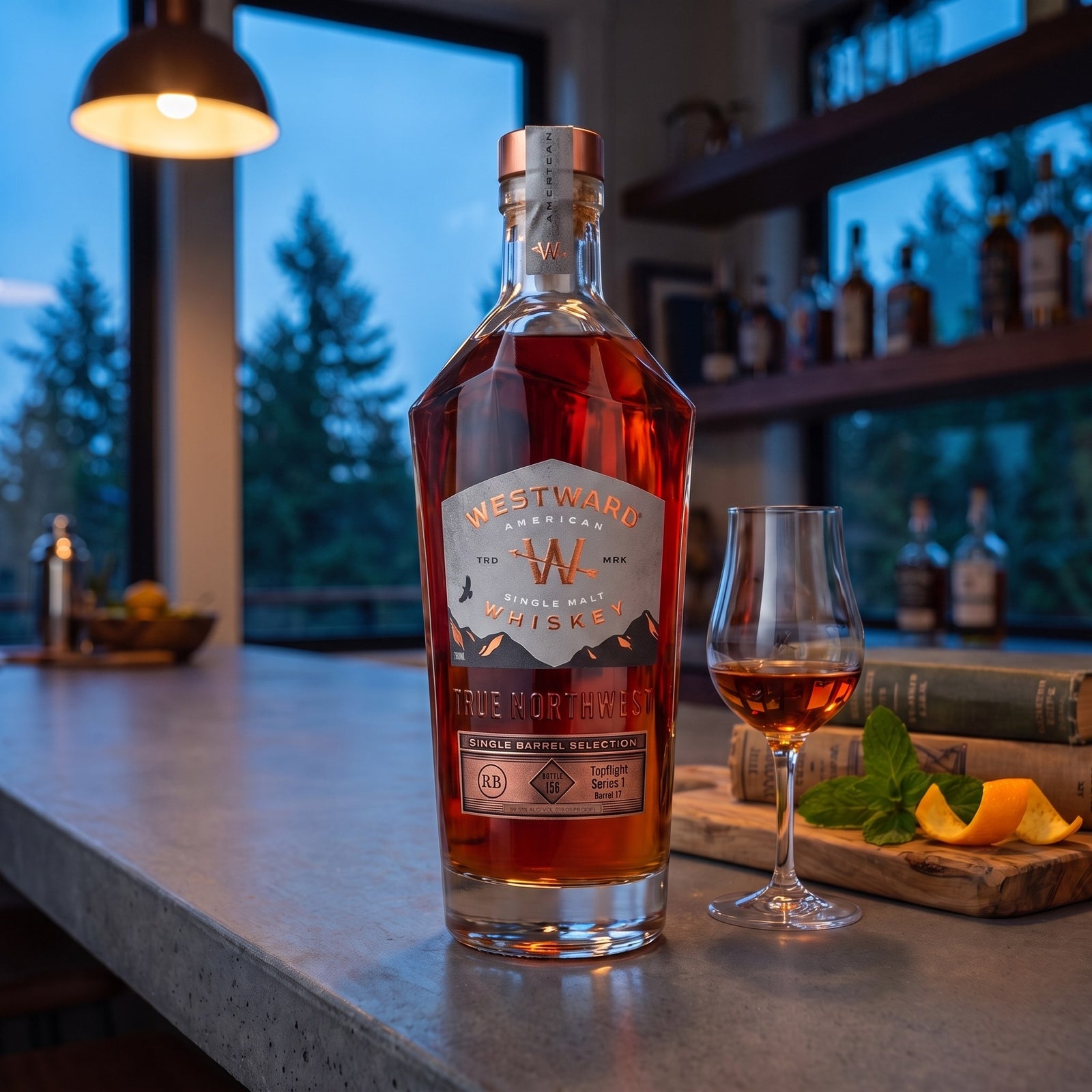 Westward Switchback single barrel American single malt on a concrete home bar at blue hour with a nosing glass, mint and orange peel